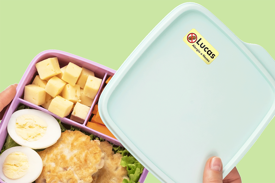 Lancheira com etiqueta de alerta de alergia, parcialmente aberta com alimentos dentro