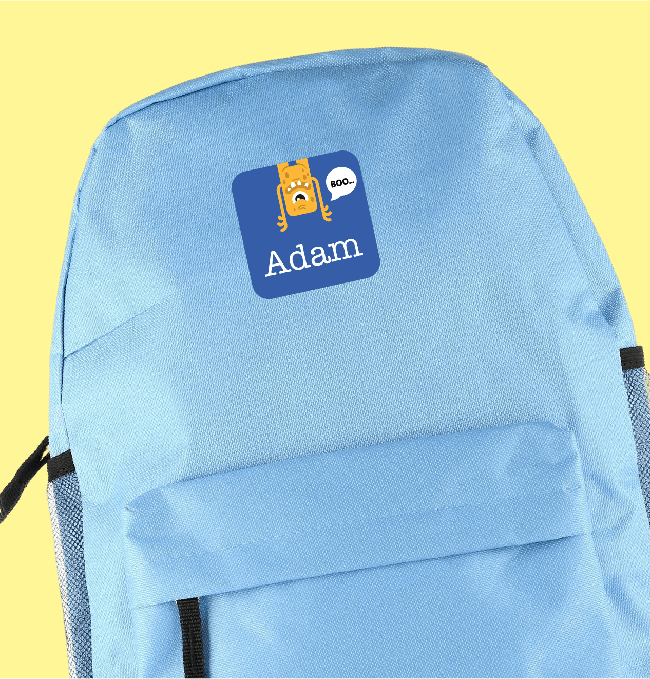Mochila azul-clara com uma maxi etiqueta personalizada com desenho de monstro e nome